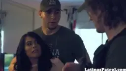 Grenzbeamter in dunklem Shirt steht dicht hinter der üppigen Latina mit langen schwarzen Locken im Büro