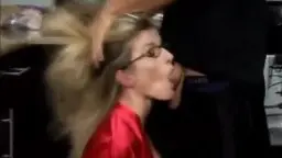 Blonde MILF im roten Satinmantel steht von hinten in einer modernen Küche an der Arbeitsplatte