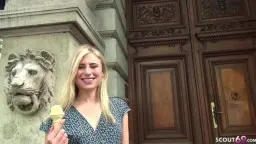 Blonde Frau mit Eis in der Hand vor klassischer Altbaufassade
