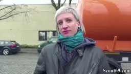 Blonde Frau mit grünem Schal läuft von hinten über Kopfsteinpflaster auf LKW zu