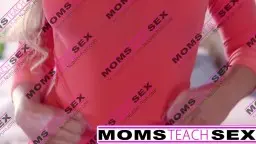Blonde MILF mit großen Titten und offenem Mund blickt lustvoll zur Seite, enger Ausschnitt auf Dekolleté und Tattoo.