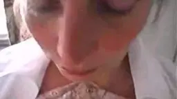 Nahaufnahme einer lächelnden reifen BBW mit riesigen nackten Brüsten und weißem Shirt