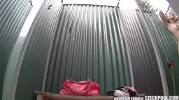 Nackte Schönheit mit nassem Haar duscht unter freiem Himmel auf Holzplattform