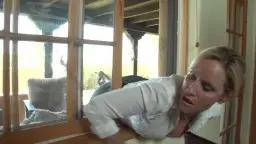 Blonde Frau in weißer Bluse telefoniert lächelnd auf der Terrasse