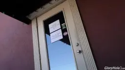 Blonde Frau greift in Pornoregale eines Sexshops