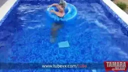 Blonde mit gelber Sonnenbrille und riesigen nassen Titten posiert am Poolrand