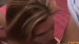 Blonde MILF mit großen Titten wird von hinten tief anal gefickt, Gesicht lustvoll verzerrt auf pinkem Bett.