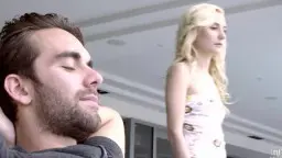 Blondes Mädchen steht neben entspanntem bärtigem Mann auf heller Couch
