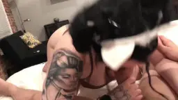 Schwarzhaariges Tattoo-Häschen mit Hasenohren saugt tief im POV auf weißer Bettwäsche