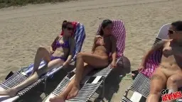Vier junge Frauen liegen nackt auf Strandliegen