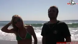 Blonde in grünem Bikini am Strand mit Mann