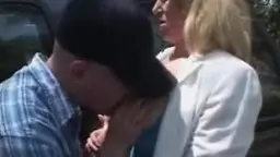 Blonde MILF mit geschlossenen Augen wird von Männerhand am Mund und Kinn gepackt