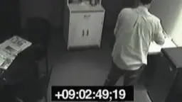 Junger Mann in heller Hemd sitzt allein an Schreibtisch in spartanischem Büro