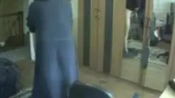 Frau mit grauen Haaren in schwarzem Kleid kniet vor nacktem Mann und bläst ihm im hellen Zimmer